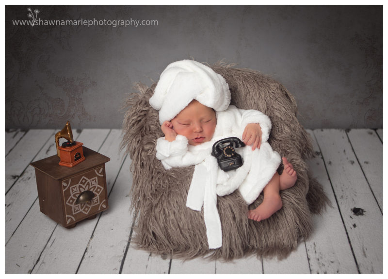 Newborn baby holding phone. 